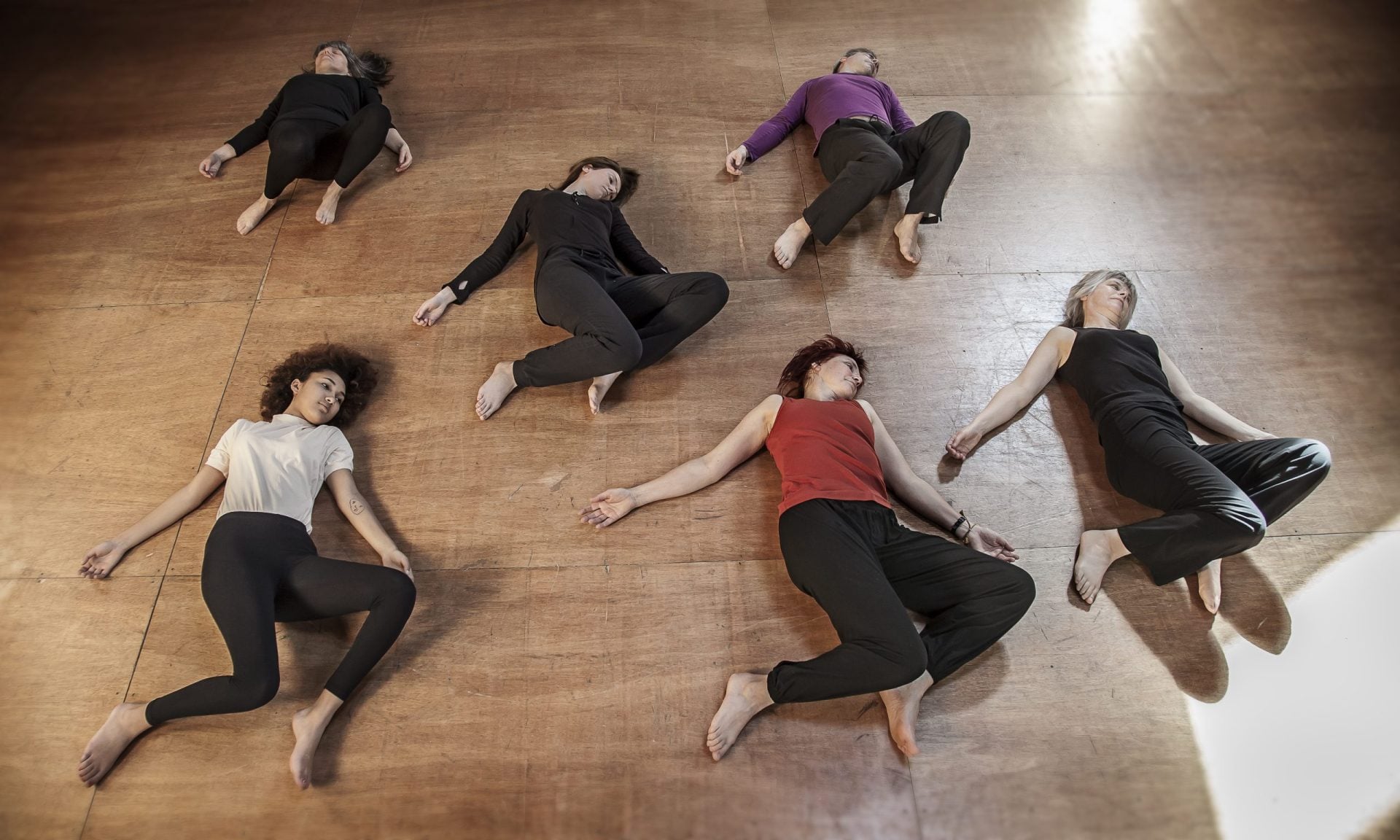 Laura Yedwab, a Kirkland Feldenkrais practitioner, gently raising a fully clothed client's arm as the client lies on the table during a Feldenkrais lesson.